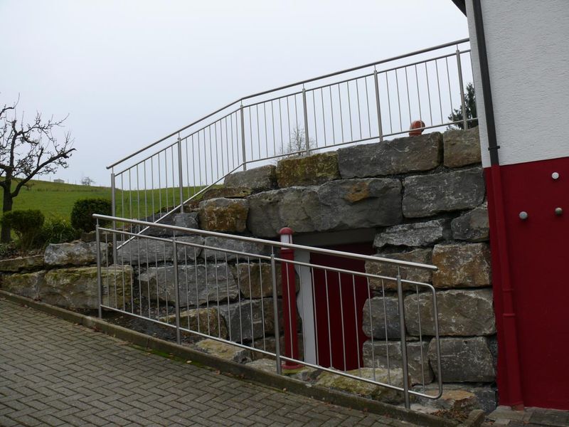Edelstahlgeländer auf einer Natursteinmauer